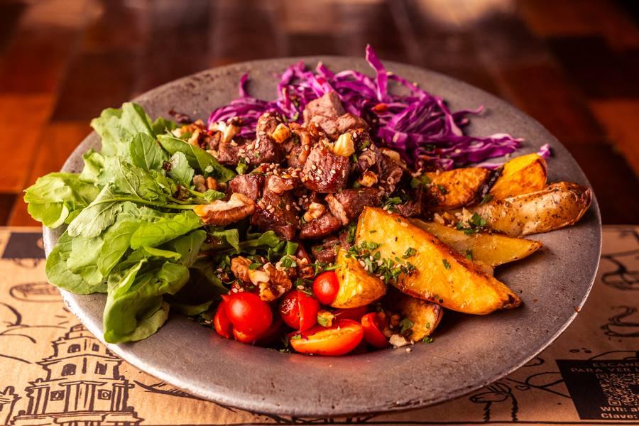A plate with fresh salad and rustic potatoes