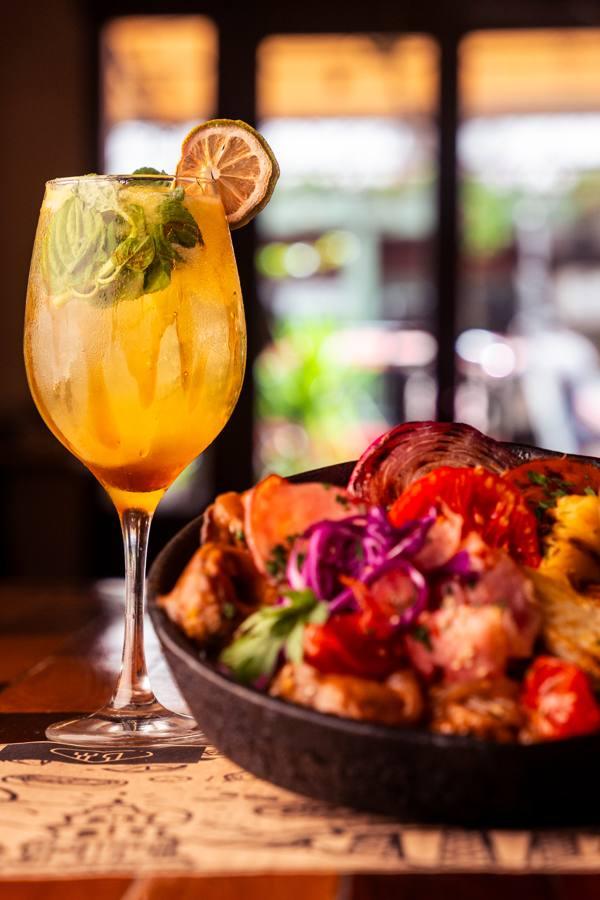 A signature cocktail with a stew in the background